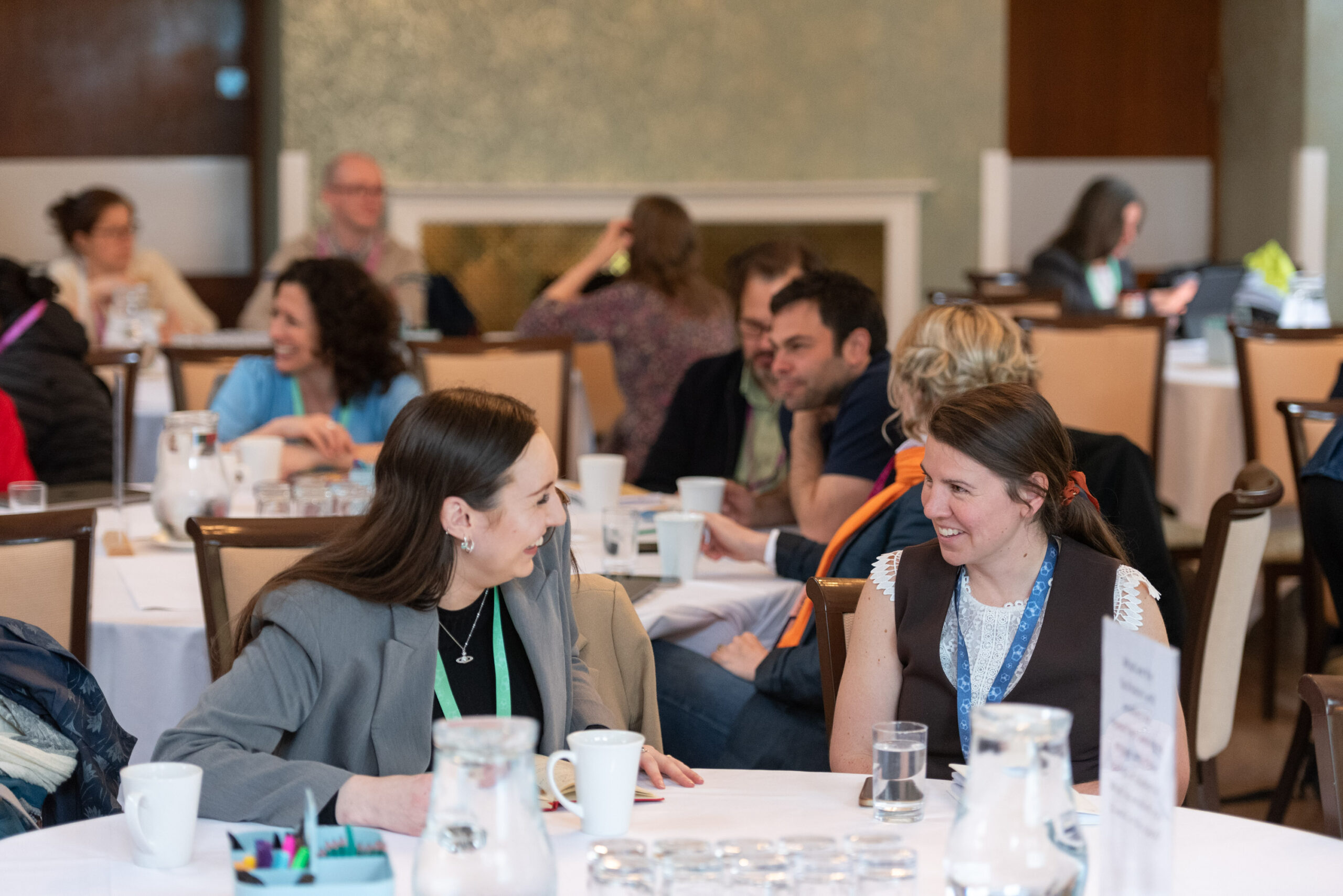 A photo of two people laughing and talking at a networking event