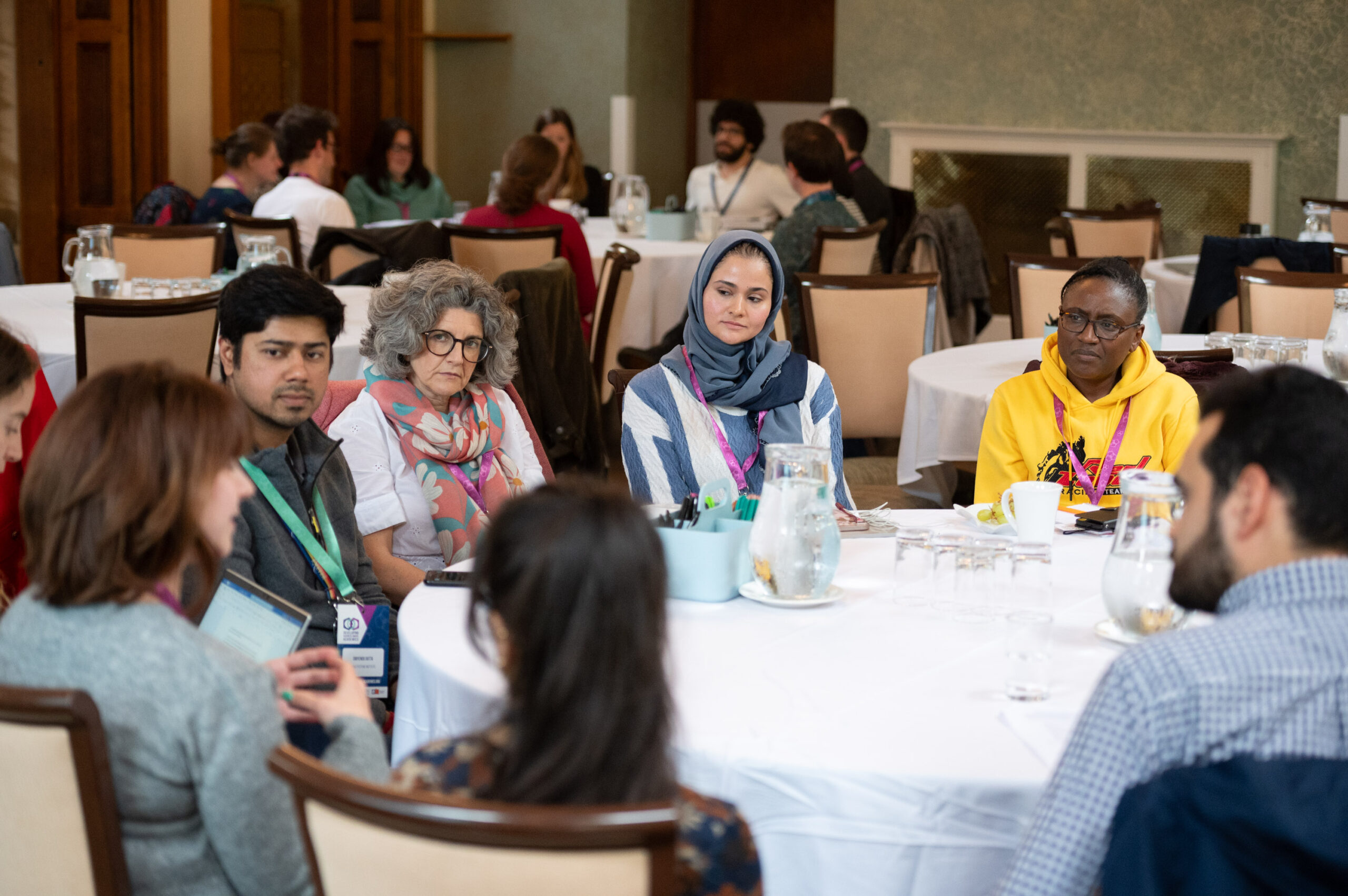 A group of researchers and facilitators sitting round a table participating in a Developing Business-Aware Academics workshop